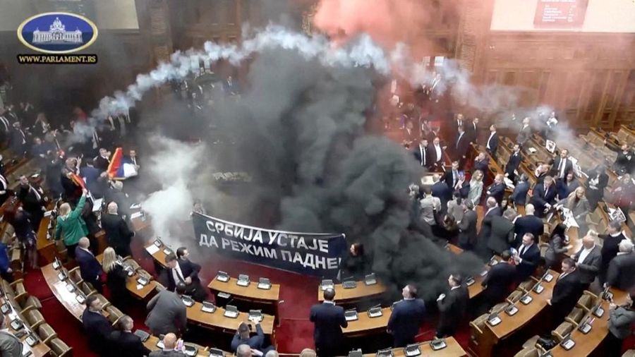 Anggota parlemen oposisi Serbia melepaskan granat asap di dalam parlemen Serbia, di Beograd, Serbia 4 Maret 2025, dalam tangkapan layar yang diambil dari sebuah video. (SERBIAN PARLIAMENT POOL / VIDEOPLUS/Handout via REUTERS)