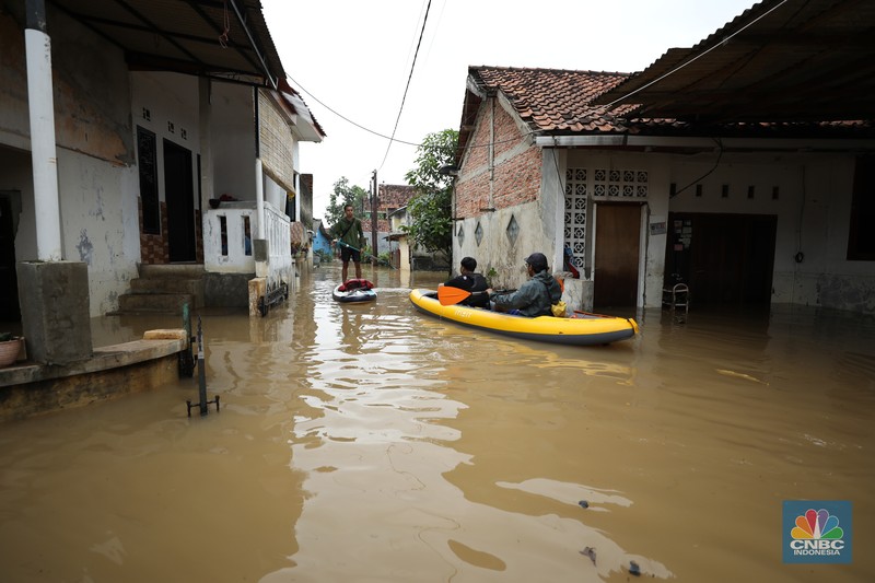Seorang warga membersihkan rumah dari sisa-sisa banjir bandang di Desa Citeko, Kecamatan Cisarua, Jawa Barat, Senin (3/3/2025). (CNBC Indonesia/Tri Susilo)