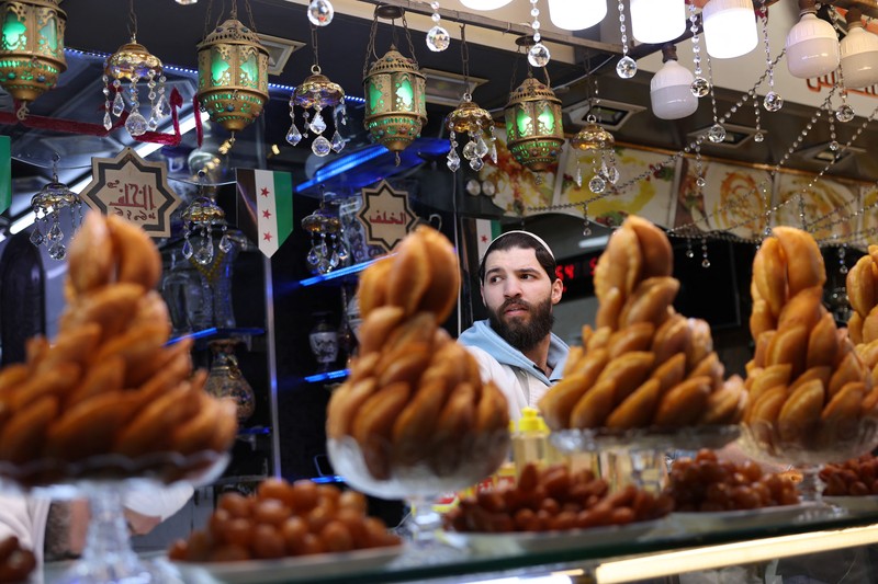 Permen tradisional dipajang saat orang-orang berbelanja di pasar selama bulan puasa Ramadan, di Damaskus, Suriah, 2 Maret 2025. (REUTERS/Yamaml Al Shaar)