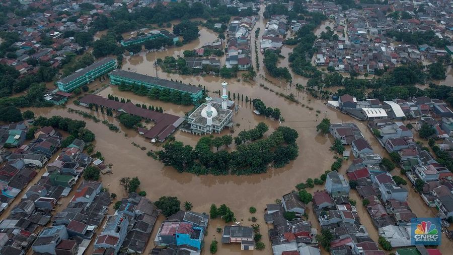 Warga melintasi banjir yang melanda Perumahan Villa Nusa Indah 1, Kecamatan Gunung Putri, Kabupaten Bogor, Jawa Barat, Selasa (4/3/2025). (CNBC Indonesia/Faisal Rahman)