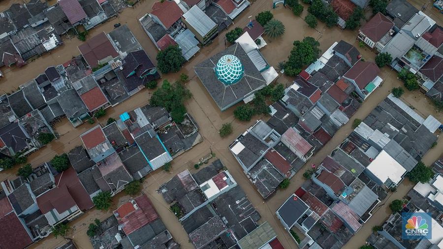 Warga melintasi banjir yang melanda Perumahan Villa Nusa Indah 1, Kecamatan Gunung Putri, Kabupaten Bogor, Jawa Barat, Selasa (4/3/2025). (CNBC Indonesia/Faisal Rahman)