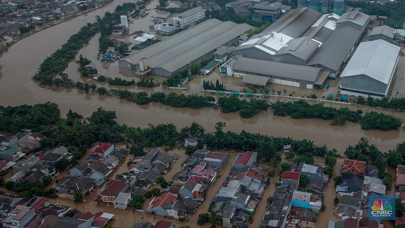 Warga melintasi banjir yang melanda Perumahan Villa Nusa Indah 1, Kecamatan Gunung Putri, Kabupaten Bogor, Jawa Barat, Selasa (4/3/2025). (վ/Faisal Rahman)