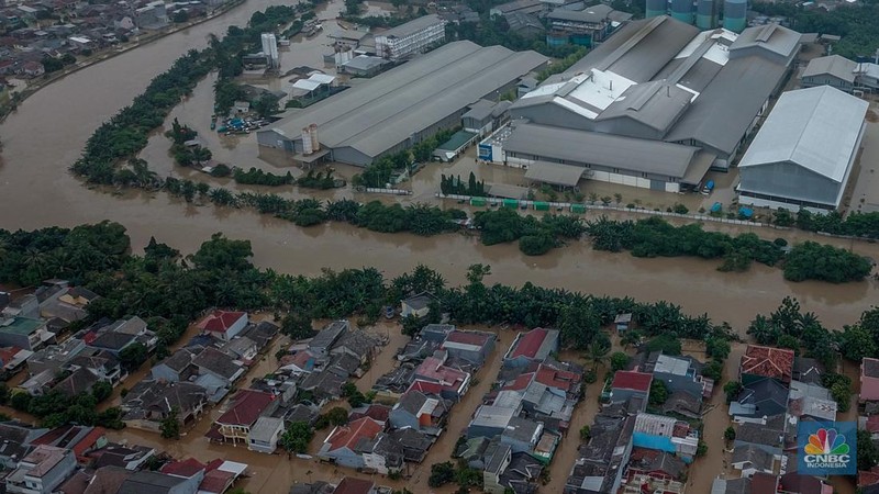 Warga melintasi banjir yang melanda Perumahan Villa Nusa Indah 1, Kecamatan Gunung Putri, Kabupaten Bogor, Jawa Barat, Selasa (4/3/2025). (վ/Faisal Rahman)