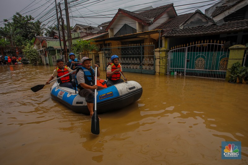 Warga melintasi banjir yang melanda Perumahan Villa Nusa Indah 1, Kecamatan Gunung Putri, Kabupaten Bogor, Jawa Barat, Selasa (4/3/2025). (վ/Faisal Rahman)