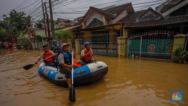 Warga melintasi banjir yang melanda Perumahan Villa Nusa Indah 1, Kecamatan Gunung Putri, Kabupaten Bogor, Jawa Barat, Selasa (4/3/2025). (վ/Faisal Rahman)