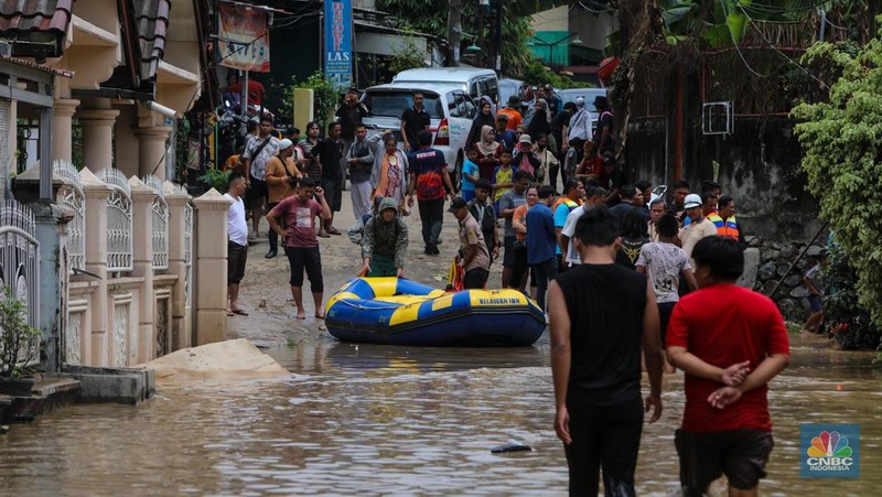 Warga melintasi banjir yang melanda Perumahan Villa Nusa Indah 1, Kecamatan Gunung Putri, Kabupaten Bogor, Jawa Barat, Selasa (4/3/2025). (վ/Faisal Rahman)