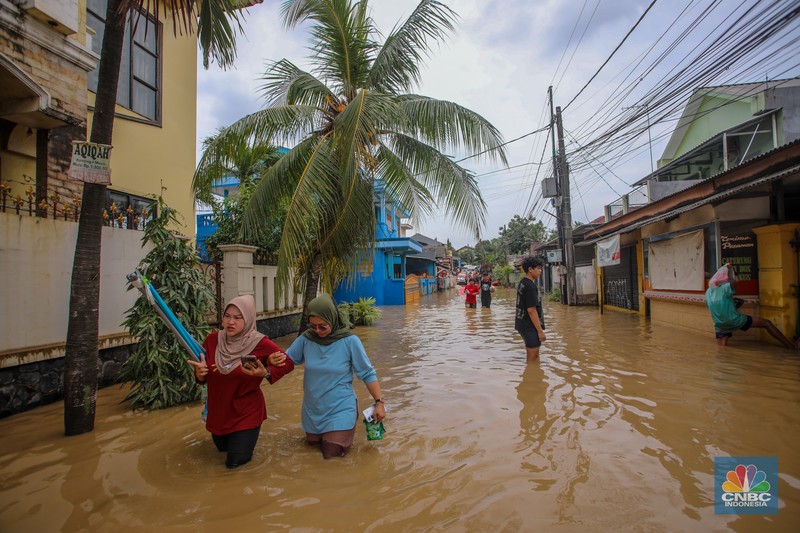 Warga melintasi banjir yang melanda Perumahan Villa Nusa Indah 1, Kecamatan Gunung Putri, Kabupaten Bogor, Jawa Barat, Selasa (4/3/2025). (վ/Faisal Rahman)