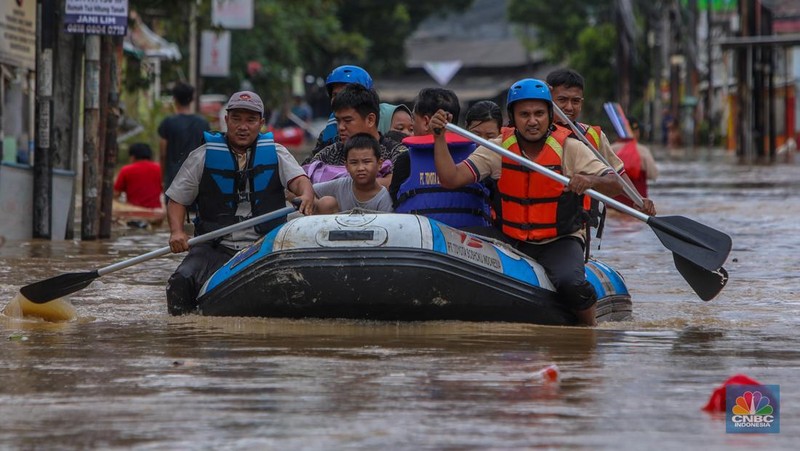 Warga melintasi banjir yang melanda Perumahan Villa Nusa Indah 1, Kecamatan Gunung Putri, Kabupaten Bogor, Jawa Barat, Selasa (4/3/2025). (վ/Faisal Rahman)