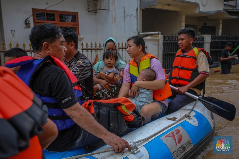 Warga melintasi banjir yang melanda Perumahan Villa Nusa Indah 1, Kecamatan Gunung Putri, Kabupaten Bogor, Jawa Barat, Selasa (4/3/2025). (վ/Faisal Rahman)