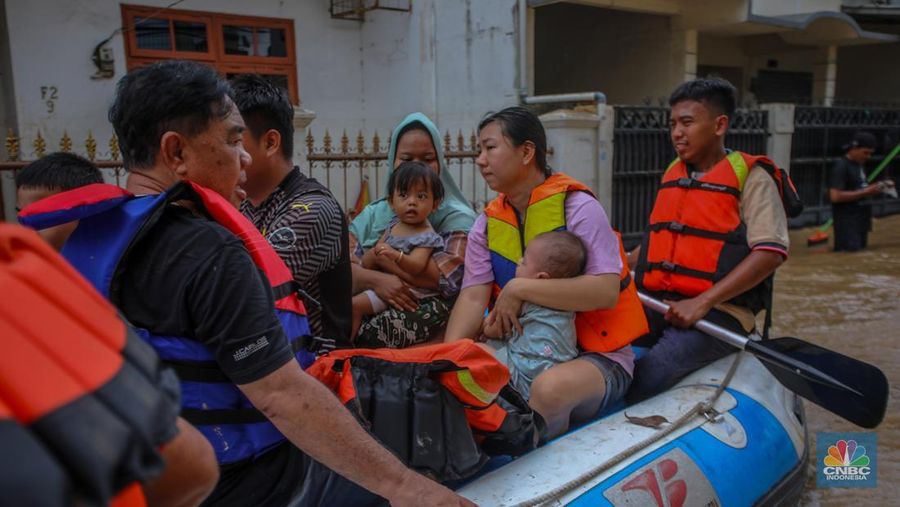 Warga melintasi banjir yang melanda Perumahan Villa Nusa Indah 1, Kecamatan Gunung Putri, Kabupaten Bogor, Jawa Barat, Selasa (4/3/2025). (CNBC Indonesia/Faisal Rahman)