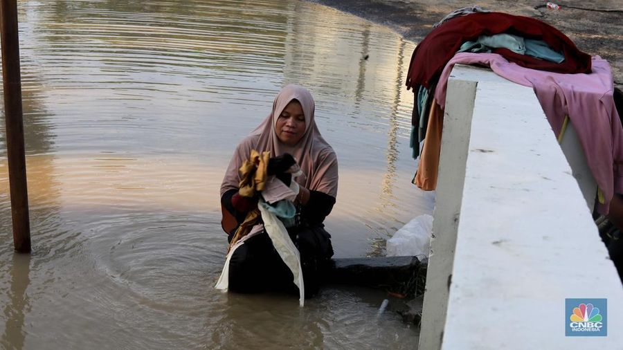 Sejumlah karyawan kios toko mengevakuasi sejumlah pakaian yang terendam banjir di halaman luar lantai bawah mall Hypermall Bekasi, Jawa Barat, Rabu 5/3. (CNBC Indonesia/Muhammad Sabki)