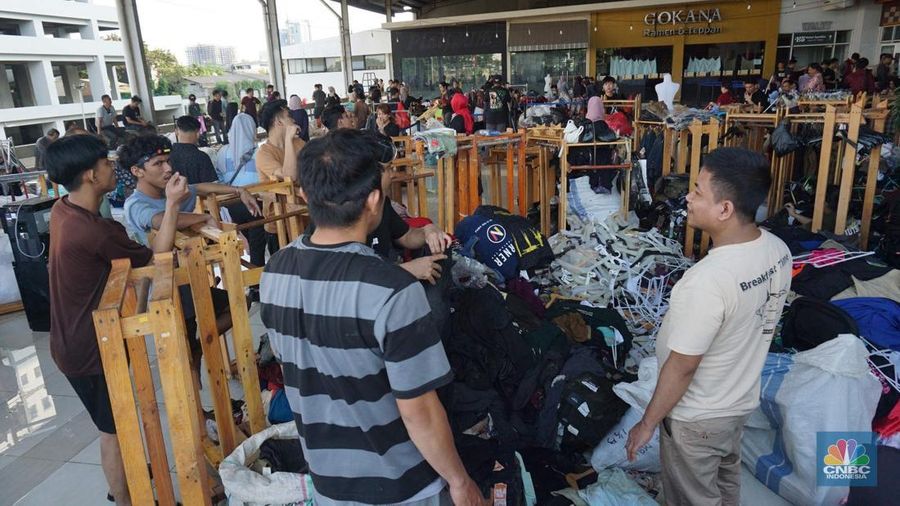 Sejumlah karyawan kios toko mengevakuasi sejumlah pakaian yang terendam banjir di halaman luar lantai bawah mall Hypermall Bekasi, Jawa Barat, Rabu 5/3. (CNBC Indonesia/Muhammad Sabki)