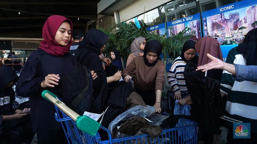 Sejumlah karyawan kios toko mengevakuasi sejumlah pakaian yang terendam banjir di halaman luar lantai bawah mall Hypermall Bekasi, Jawa Barat, Rabu 5/3. (CNBC Indonesia/Muhammad Sabki)