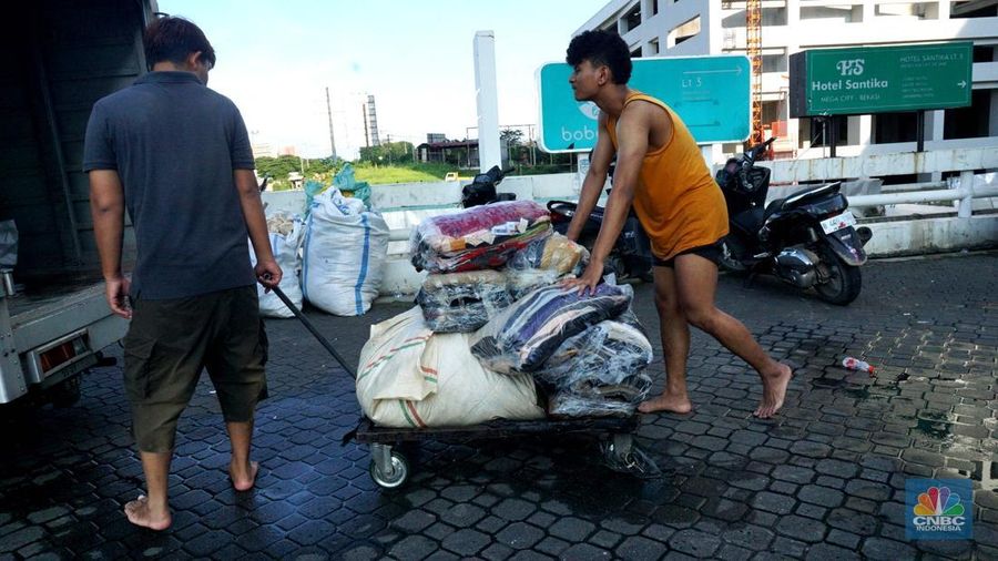 Sejumlah karyawan kios toko mengevakuasi sejumlah pakaian yang terendam banjir di halaman luar lantai bawah mall Hypermall Bekasi, Jawa Barat, Rabu 5/3. (վ/Muhammad Sabki)