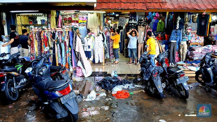 Sejumlah pedagang mulai membersihakan sisa-sisa genangan air di kawasan Pasar Cipulir, Jakarta, Rabu (5/3/2025). Salah satu lokasi yang terdampak banjir dari luapan kali Pesanggrahan yakni Pasar Cipulir yang berangsur beroperasi kembali. (CNBC Indonesia/Tri Susilo)