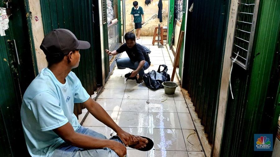 Sejumlah pedagang mulai membersihakan sisa-sisa genangan air di kawasan Pasar Cipulir, Jakarta, Rabu (5/3/2025). Salah satu lokasi yang terdampak banjir dari luapan kali Pesanggrahan yakni Pasar Cipulir yang berangsur beroperasi kembali. (CNBC Indonesia/Tri Susilo)