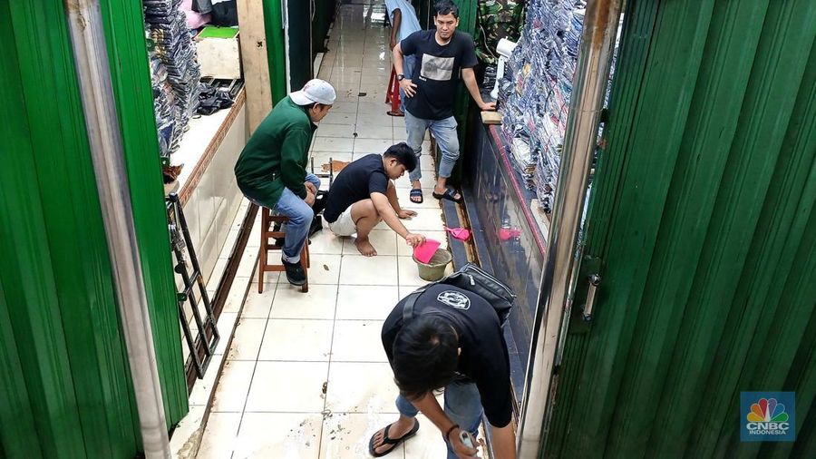 Sejumlah pedagang mulai membersihakan sisa-sisa genangan air di kawasan Pasar Cipulir, Jakarta, Rabu (5/3/2025). Salah satu lokasi yang terdampak banjir dari luapan kali Pesanggrahan yakni Pasar Cipulir yang berangsur beroperasi kembali. (CNBC Indonesia/Tri Susilo)