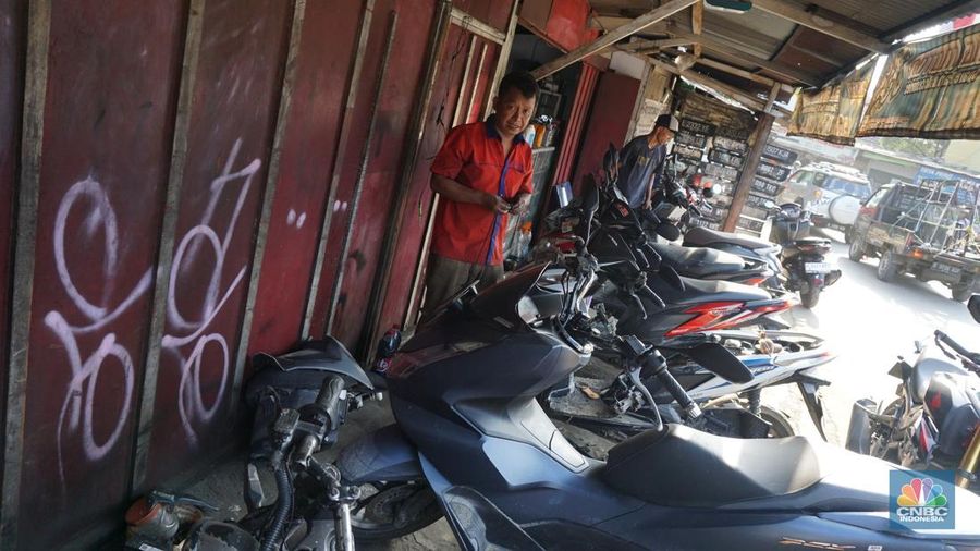 Seorang montir memperbaiki motor yang rusak terendam banjir di kawasan Bekasi, Jawa Barat, Rabu (5/3/2025). (CNBC Indonesia/Muhammad Sabki)