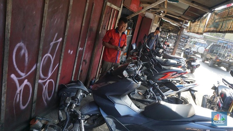 Seorang montir memperbaiki motor yang rusak terendam banjir di kawasan Bekasi, Jawa Barat, Rabu (5/3/2025). (վ/Muhammad Sabki)