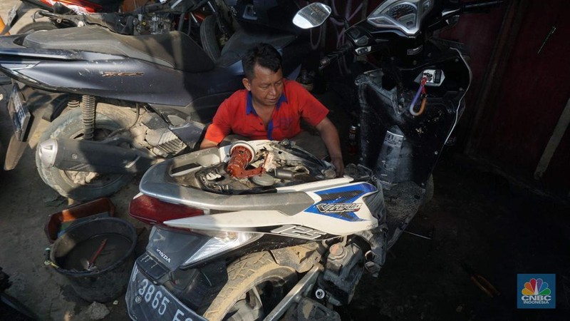 Seorang montir memperbaiki motor yang rusak terendam banjir di kawasan Bekasi, Jawa Barat, Rabu (5/3/2025). (վ/Muhammad Sabki)