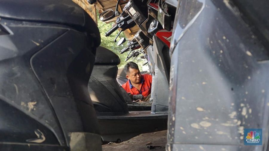 Seorang montir memperbaiki motor yang rusak terendam banjir di kawasan Bekasi, Jawa Barat, Rabu (5/3/2025). (CNBC Indonesia/Muhammad Sabki)