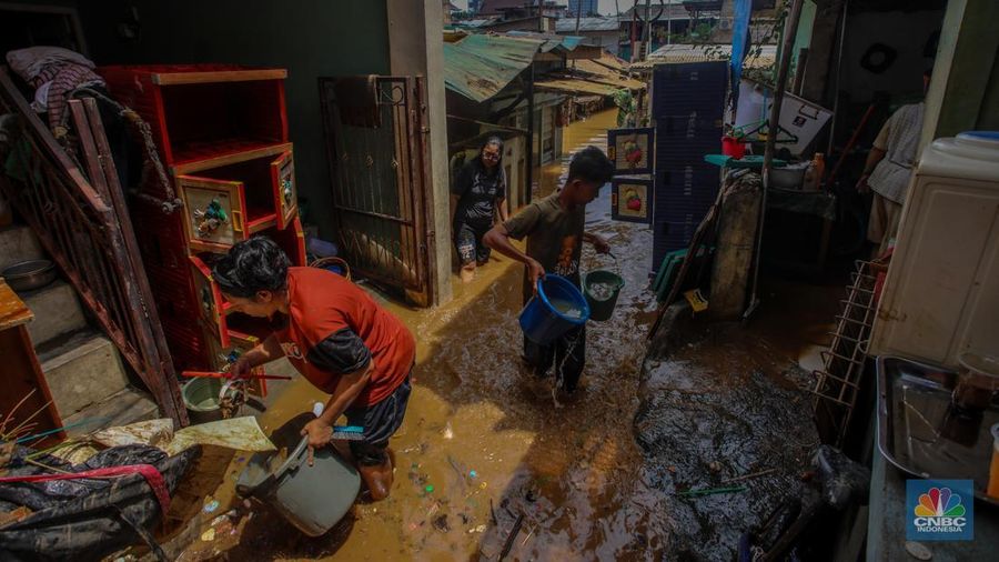 Warga melintasi banjir yang melanda pemukiman padat di Kelurahan Pengadegan, Pancoran, Jakarta, Rabu (5/3/2025). (CNBC Indonesia/Faisal Rahman)