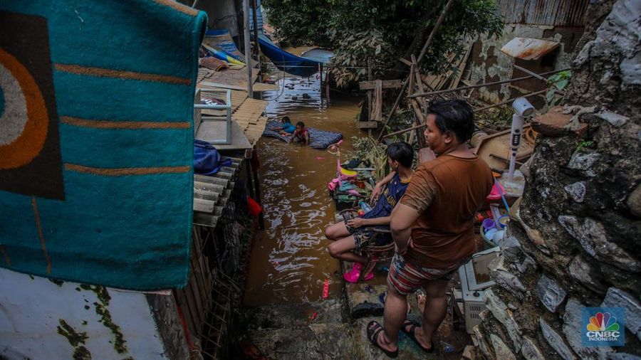 Warga melintasi banjir yang melanda pemukiman padat di Kelurahan Pengadegan, Pancoran, Jakarta, Rabu (5/3/2025). (CNBC Indonesia/Faisal Rahman)