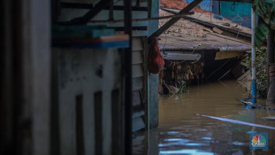 Warga melintasi banjir yang melanda pemukiman padat di Kelurahan Pengadegan, Pancoran, Jakarta, Rabu (5/3/2025). (CNBC Indonesia/Faisal Rahman)