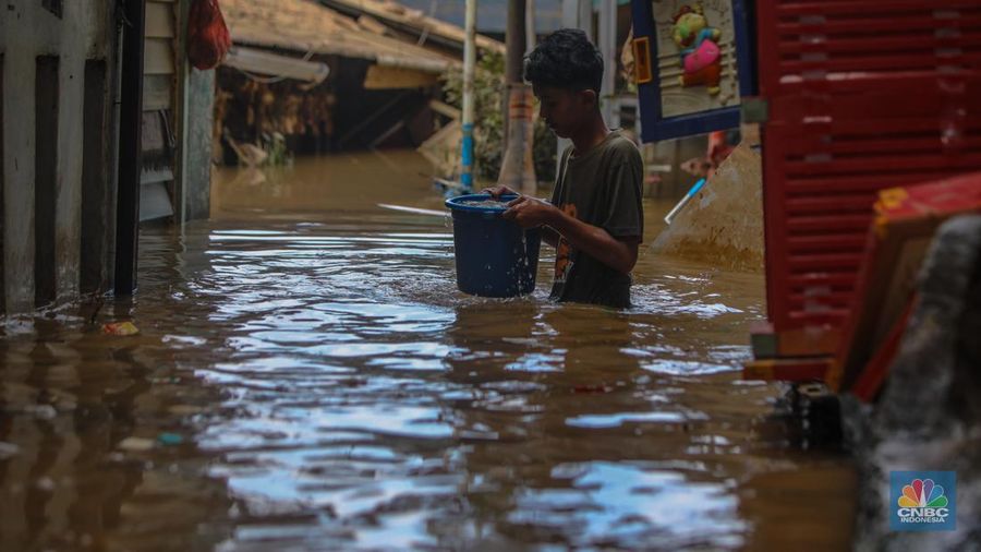 Warga melintasi banjir yang melanda pemukiman padat di Kelurahan Pengadegan, Pancoran, Jakarta, Rabu (5/3/2025). (CNBC Indonesia/Faisal Rahman)