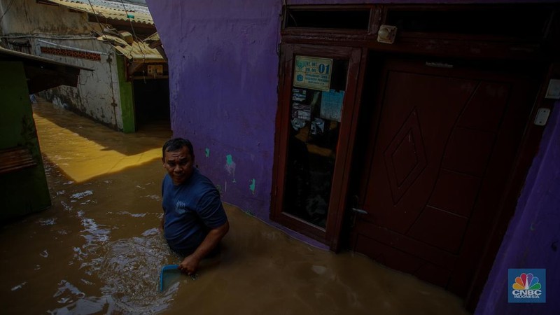 Warga melintasi banjir yang melanda pemukiman padat di Kelurahan Pengadegan, Pancoran, Jakarta, Rabu (5/3/2025). (վ/Faisal Rahman)