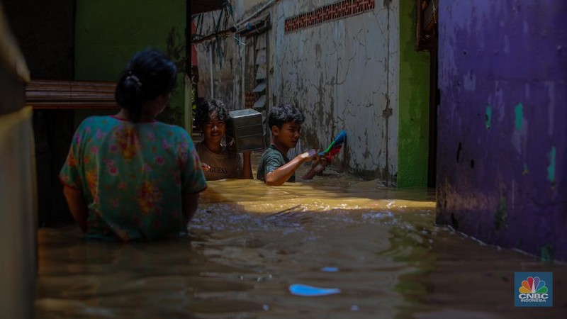 Warga melintasi banjir yang melanda pemukiman padat di Kelurahan Pengadegan, Pancoran, Jakarta, Rabu (5/3/2025). (վ/Faisal Rahman)
