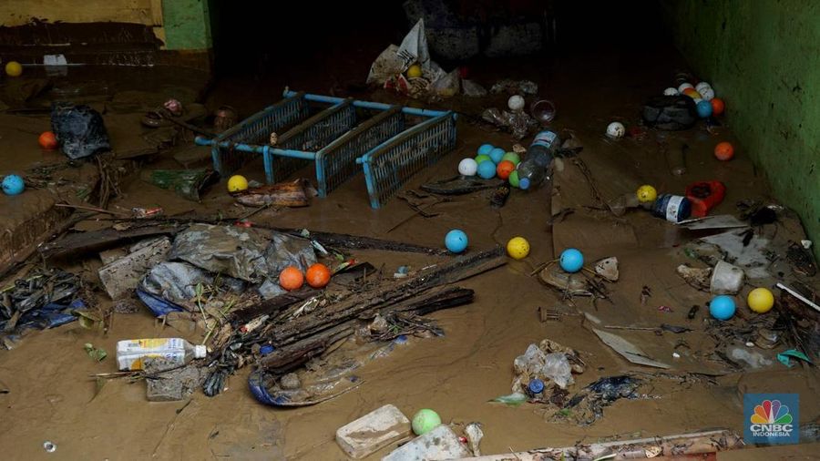 Warga membersihkan lumpur sisa banjir di Perumahan Pondok Gede Permai, Bekasi, Jawa Barat, Rabu (5/3/2025). (CNBC Indonesia/Muhammad Sabki)