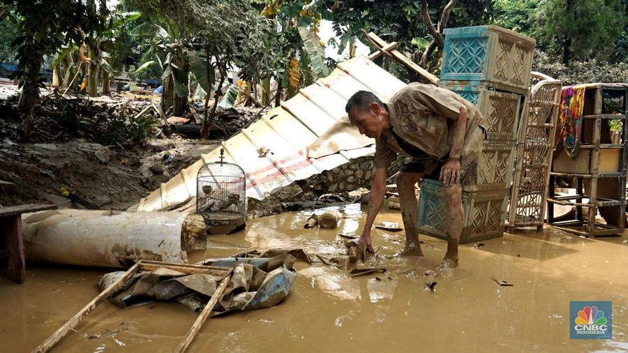 Warga membersihkan lumpur sisa banjir di Perumahan Pondok Gede Permai, Bekasi, Jawa Barat, Rabu (5/3/2025). (CNBC Indonesia/Muhammad Sabki)