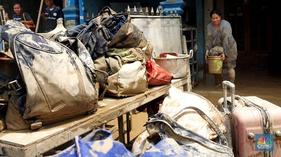 Warga membersihkan lumpur sisa banjir di Perumahan Pondok Gede Permai, Bekasi, Jawa Barat, Rabu (5/3/2025). (CNBC Indonesia/Muhammad Sabki)