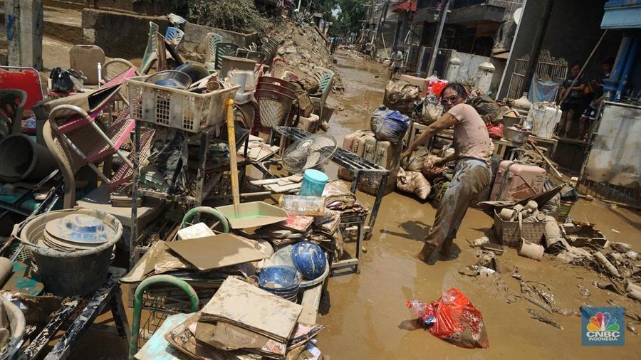 Warga membersihkan lumpur sisa banjir di Perumahan Pondok Gede Permai, Bekasi, Jawa Barat, Rabu (5/3/2025). (CNBC Indonesia/Muhammad Sabki)