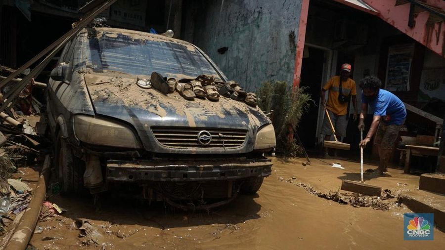 Seorang warga membersihkan rumah dari sisa-sisa banjir bandang di Desa Citeko, Kecamatan Cisarua, Jawa Barat, Senin (3/3/2025). (CNBC Indonesia/Tri Susilo)