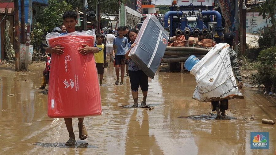 Warga membersihkan lumpur sisa banjir di Perumahan Pondok Gede Permai, Bekasi, Jawa Barat, Rabu (5/3/2025). (CNBC Indonesia/Muhammad Sabki)