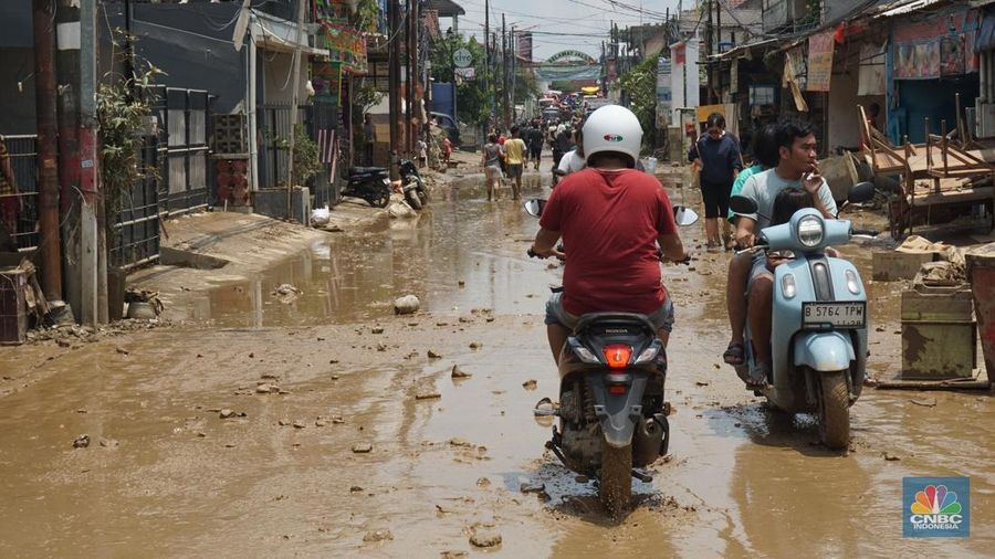 Warga membersihkan lumpur sisa banjir di Perumahan Pondok Gede Permai, Bekasi, Jawa Barat, Rabu (5/3/2025). (CNBC Indonesia/Muhammad Sabki)