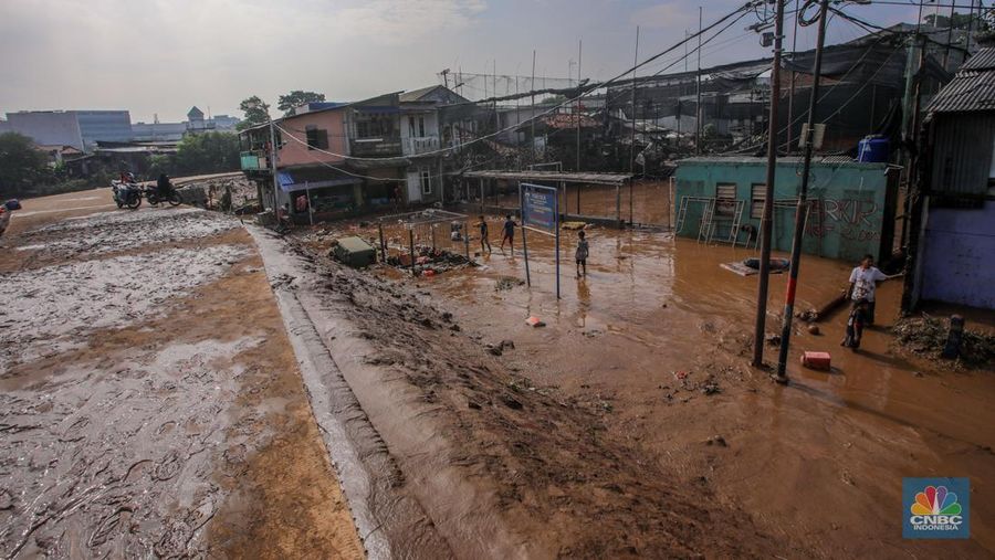 Warga membersihkan lumpur sisa endapan banjir di kawasan Rawajati, Jakarta, Rabu (5/3/2025). (CNBC Indonesia/Faisal Rahman)