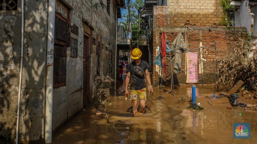 Warga membersihkan lumpur sisa endapan banjir di kawasan Rawajati, Jakarta, Rabu (5/3/2025). (CNBC Indonesia/Faisal Rahman)