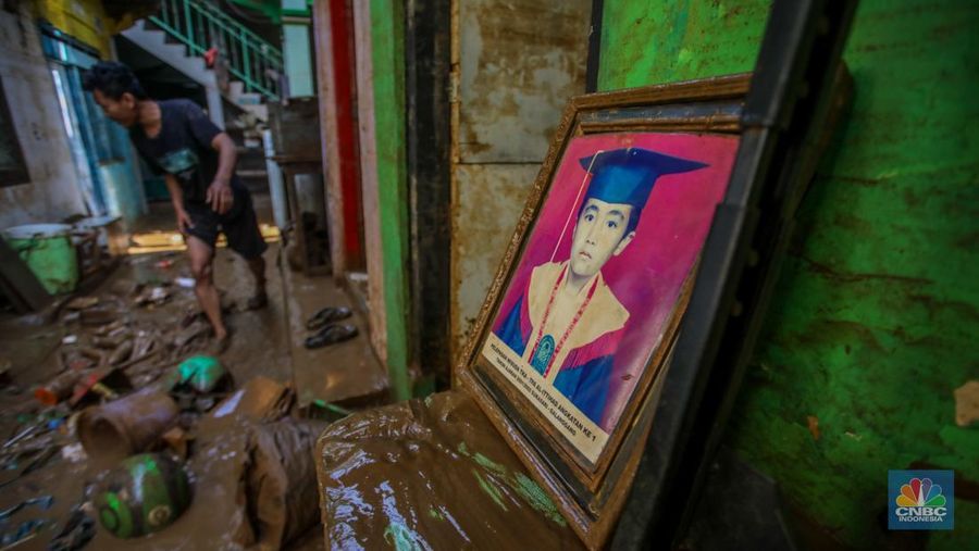 Warga membersihkan lumpur sisa endapan banjir di kawasan Rawajati, Jakarta, Rabu (5/3/2025). (CNBC Indonesia/Faisal Rahman)