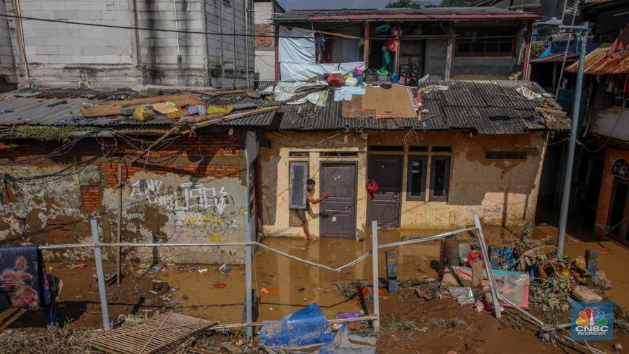 Warga membersihkan lumpur sisa endapan banjir di kawasan Rawajati, Jakarta, Rabu (5/3/2025). (CNBC Indonesia/Faisal Rahman)