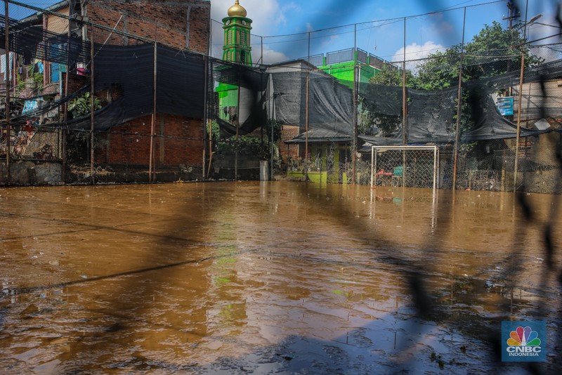 Warga membersihkan lumpur sisa endapan banjir di kawasan Rawajati, Jakarta, Rabu (5/3/2025). (CNBC Indonesia/Faisal Rahman)