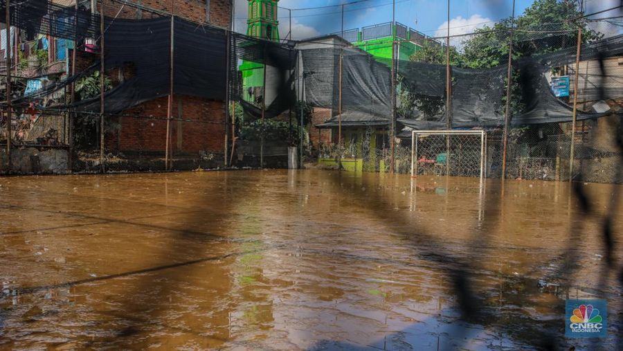 Warga membersihkan lumpur sisa endapan banjir di kawasan Rawajati, Jakarta, Rabu (5/3/2025). (CNBC Indonesia/Faisal Rahman)