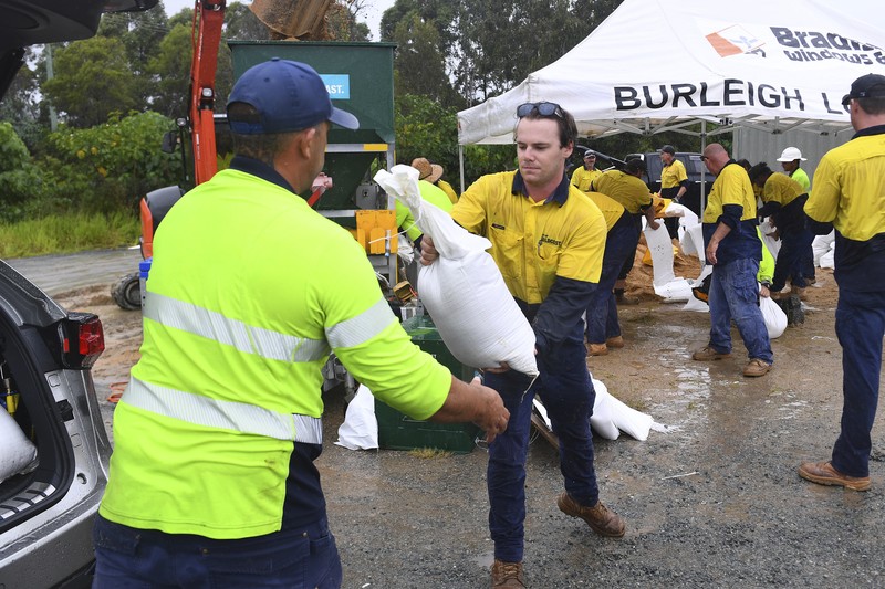 Warga mengumpulkan karung pasir di sebuah depot di Pulau Bribie, Queensland, Selasa, 4 Maret 2025, saat mereka bersiap menghadapi Siklon Alfred yang mendekat. (Jono Searle/AAP Image via AP)