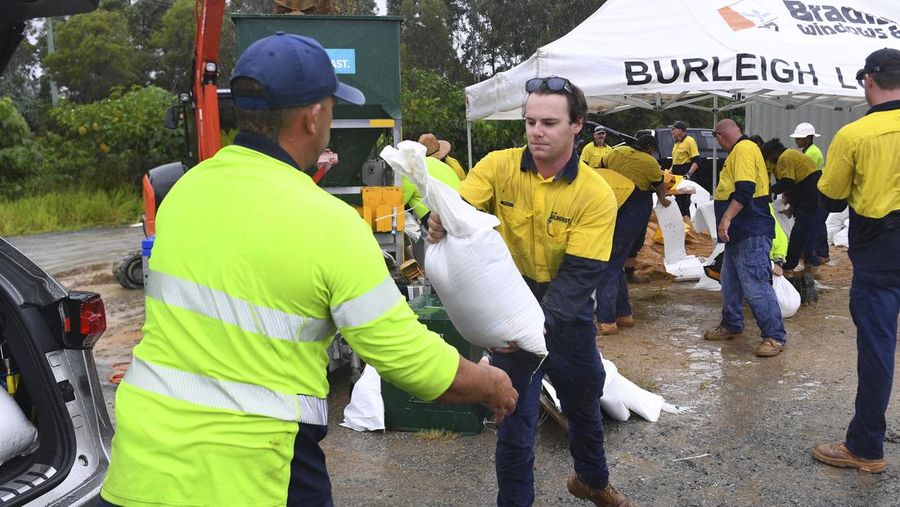 Warga mengumpulkan karung pasir di sebuah depot di Pulau Bribie, Queensland, Selasa, 4 Maret 2025, saat mereka bersiap menghadapi Siklon Alfred yang mendekat. (Jono Searle/AAP Image via AP)