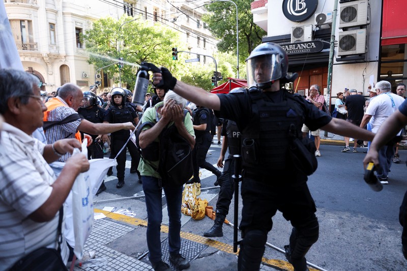 Polisi anti huru hara dan demonstran saling berhadapan selama protes untuk mendapatkan pensiun yang lebih baik bagi para pensiunan di Buenos Aires, Argentina, Rabu, 5 Maret 2025. (AP Photo/Rodrigo Abd)