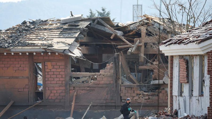 Officials stand near damaged buildings after South Korea's Air Force said that Mk82 bombs fell from a KF-16 jet outside the shooting range during joint live-fire exercises near the demilitarized zone separating two Koreas in Pocheon, South Korea, March 6, 2025. REUTERS/Kim Hong-Ji