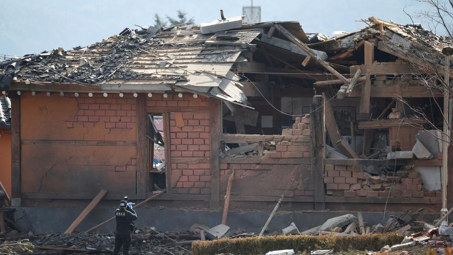 Officials stand near damaged buildings after South Korea's Air Force said that Mk82 bombs fell from a KF-16 jet outside the shooting range during joint live-fire exercises near the demilitarized zone separating two Koreas in Pocheon, South Korea, March 6, 2025. REUTERS/Kim Hong-Ji