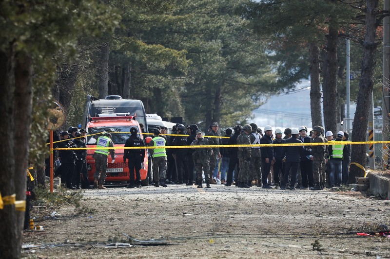 Officials stand near damaged buildings after South Korea's Air Force said that Mk82 bombs fell from a KF-16 jet outside the shooting range during joint live-fire exercises near the demilitarized zone separating two Koreas in Pocheon, South Korea, March 6, 2025. REUTERS/Kim Hong-Ji